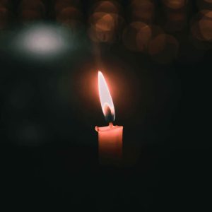 candle glowing in dark room playlist cover